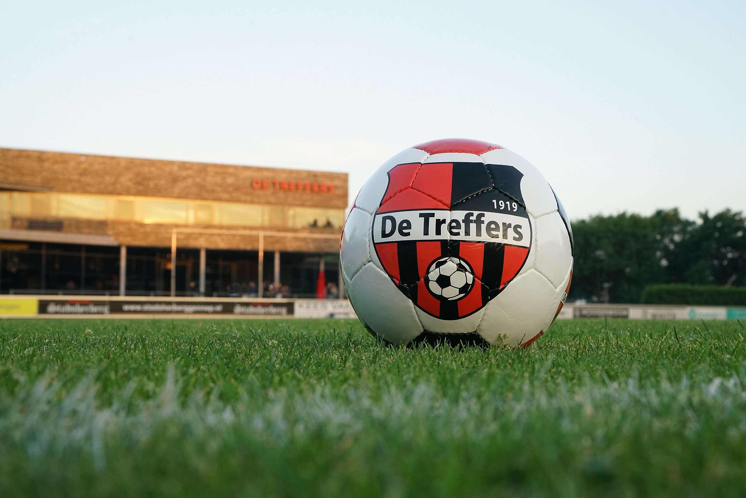 De Treffers-bal met het clubwapen in het gouden avondlicht op Sportpark Zuid